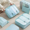 A set of nine portable mesh storage organizers in light blue and white are displayed on a wooden surface.