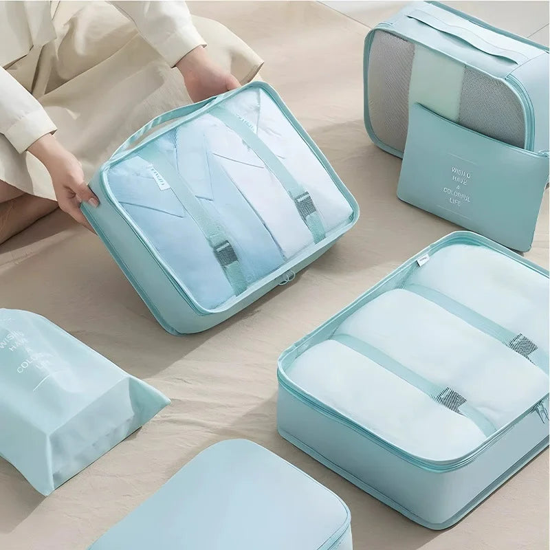 A set of nine portable mesh storage organizers in light blue and white are displayed on a wooden surface.