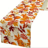 Autumn fall leaves table runner featuring orange and yellow leaves and white pumpkins