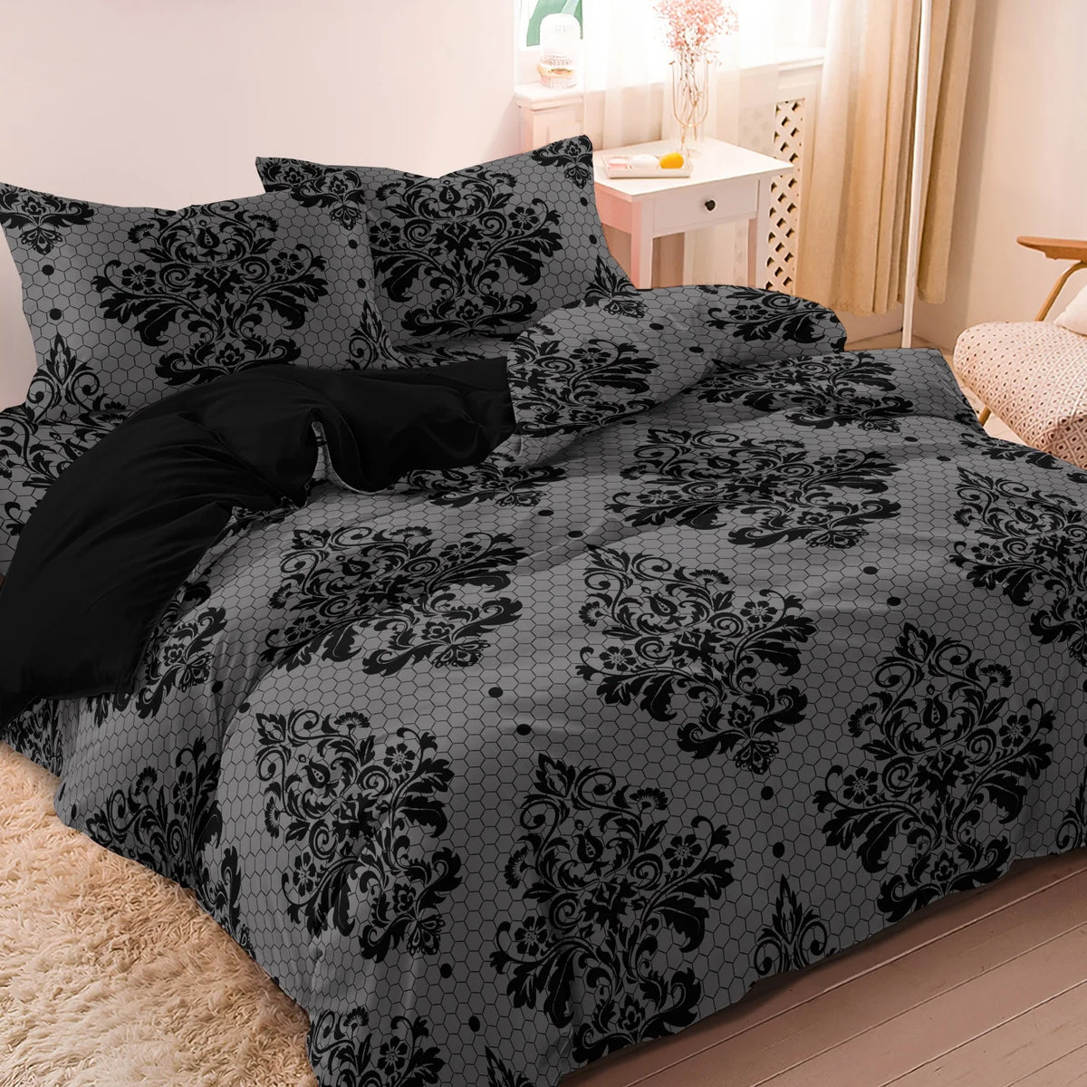 A black and gray damask pattern duvet cover set displayed on a bed with a light wood nightstand in the background.