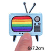 A light blue embroidered patch shaped like a television with antennae and a rainbow stripe on the screen.