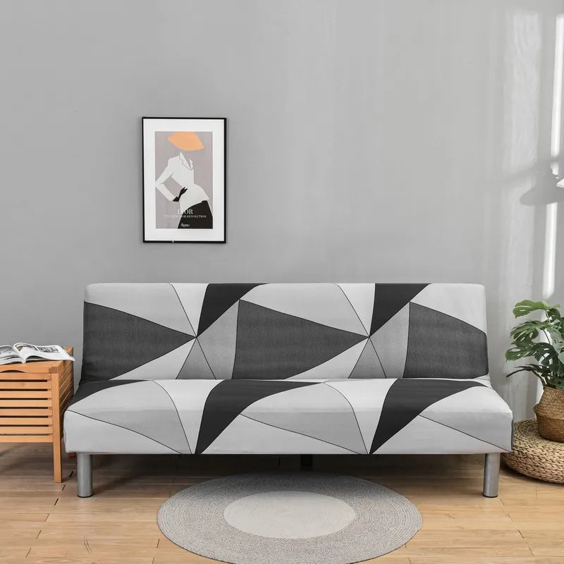 A modern gray sofa with black and white geometric print slipcovers sits in a bright room.