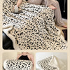 A leopard print jacquard knit throw blanket draped over a sofa and shown in various close-up views.