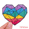 A heart-shaped embroidered patch featuring a colorful, geometric design with shades of blue, purple, green, yellow, and pink.