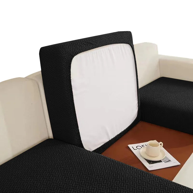 A black sofa seat protector cushion cover with a white insert shown on a light-colored sofa.