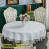 White embroidered lace tablecloth with an elegant scalloped edge displayed on a round table.