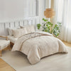 A beige embossed leaf duvet cover set displayed on a bed with white linens and natural light.