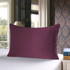 A deep plum colored silk pillowcase resting on a white surface in a well-lit room.
