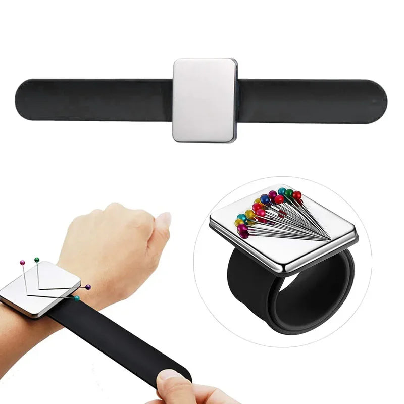 A black magnetic wrist pincushion with a silver square top and a silicone band is shown being used on a hand.