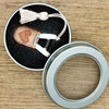 Mini precision sewing scissors with a leather cover and white grip, shown next to a metal ring.