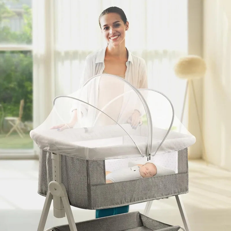 A woman is shown smiling while a portable bassinet with a clear mosquito net cover for a baby is displayed.