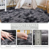 Close-up view of a dark gray plush long-pile area rug showing dense fur texture and thickness.