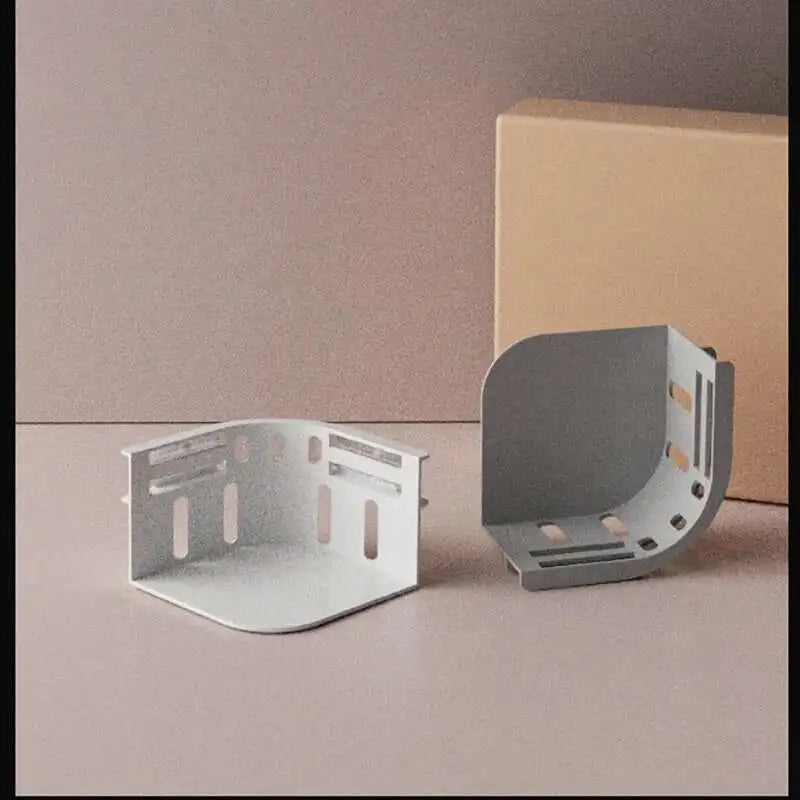 A set of three silver invisible bed sheet clips are displayed next to a cardboard box.
