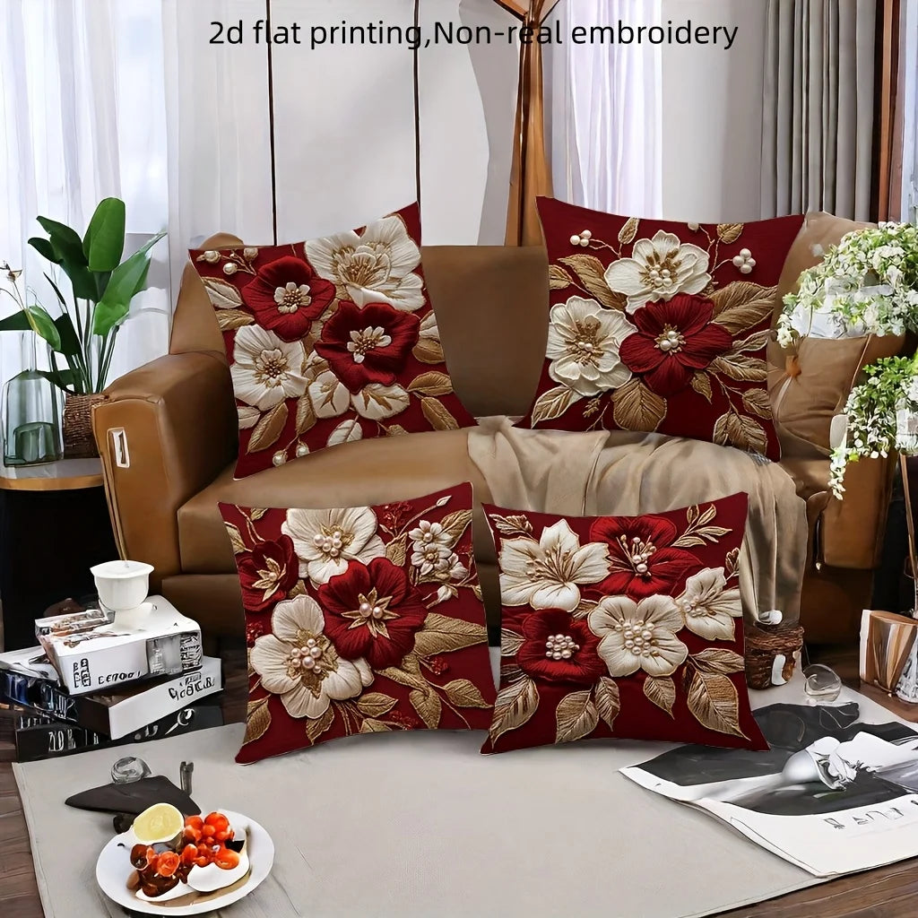 A collection of red and cream floral embroidered pillow covers displayed on a sofa.