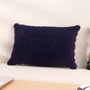 A dark purple inflatable travel neck pillow resting on a white surface.