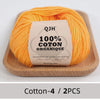 A ball of bright orange 100% organic cotton yarn labeled QJH for knitting and crochet
