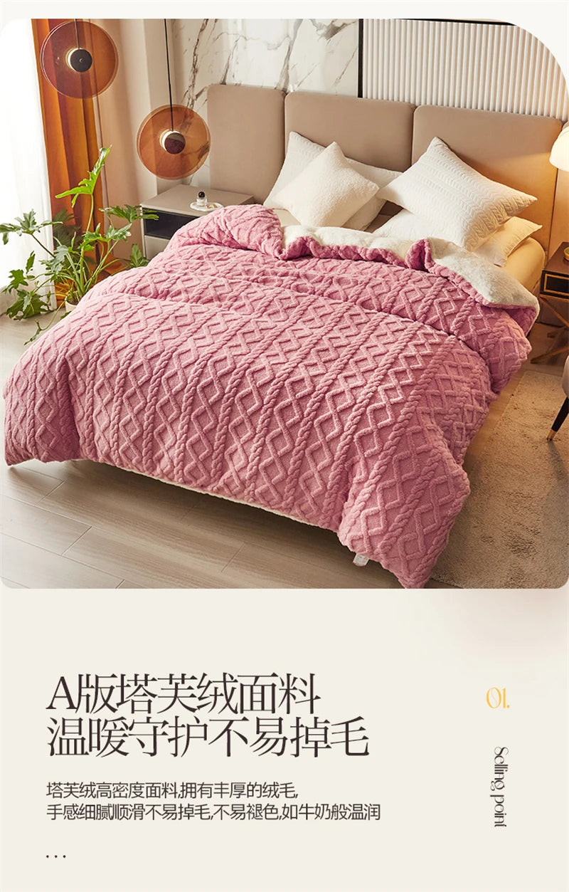 A pink quilted fleece blanket displayed on a bed, next to a beige headboard.