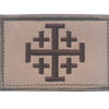 A rectangular embroidered patch featuring a dark brown cross design on a light beige fabric background.