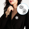 A close-up of a woman wearing a black coat and turtleneck, featuring silver snowflake locking pins on the lapel.