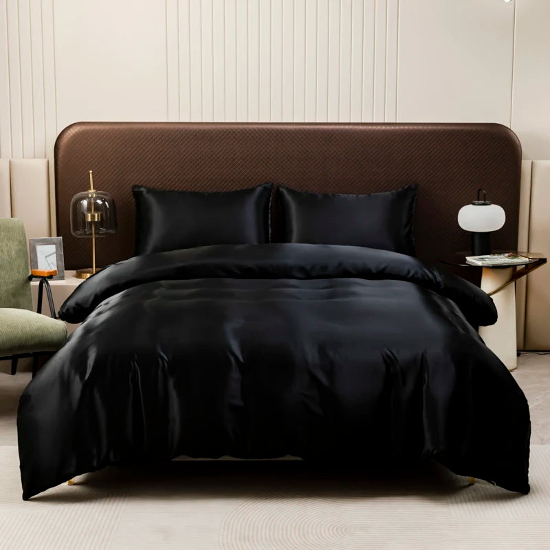 A luxurious black satin bedding set is displayed on a bed with brown upholstery and white paneling.
