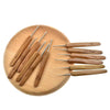A set of wooden crochet and knitting needles with various sizes arranged on a light wooden board.