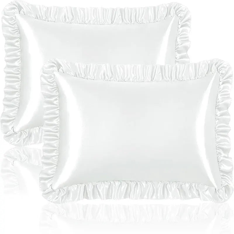 A set of two white ruffled satin pillowcases with silky envelope closures.