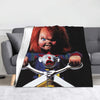 A flannel throw blanket featuring a graphic of Chucky from the horror movie, with his face and knife visible.
