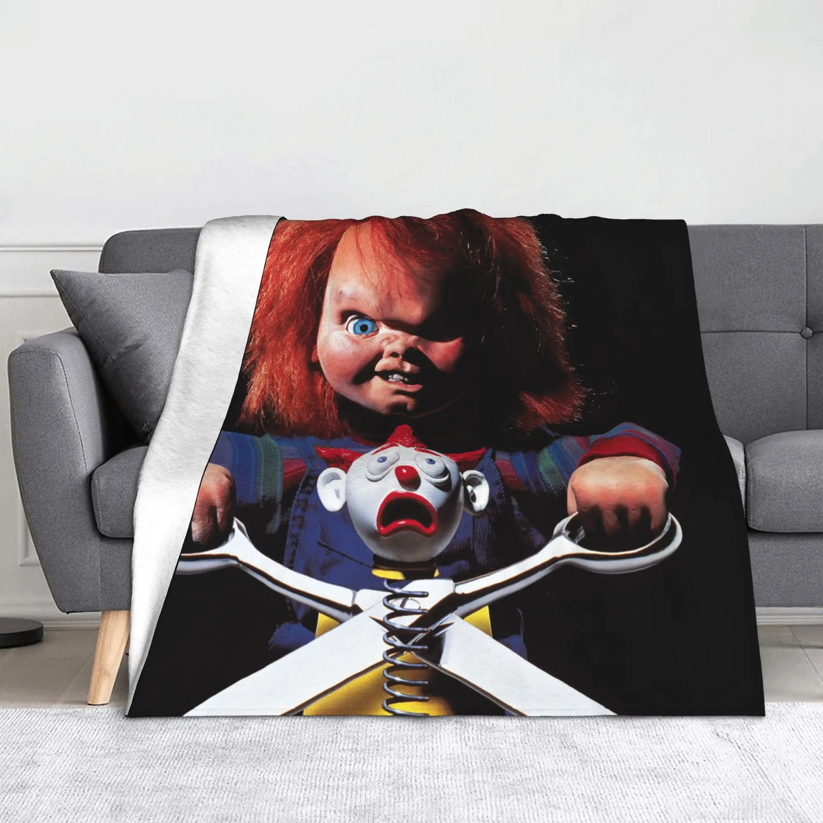 A flannel throw blanket featuring a graphic of Chucky from the horror movie, with his face and knife visible.
