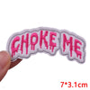 Pink embroidered patch spelling out CHOKE ME