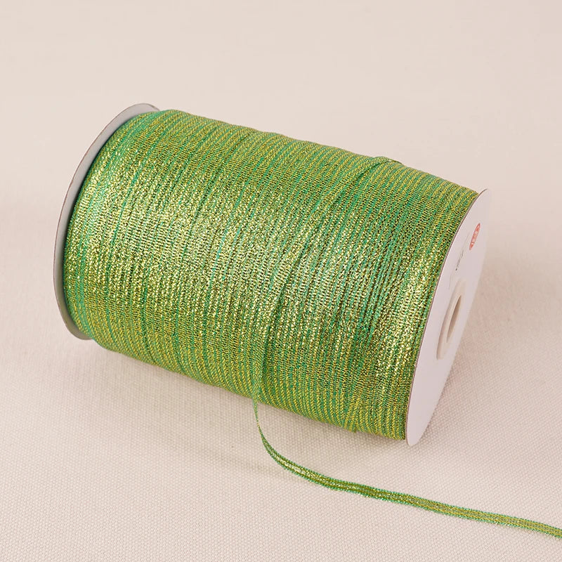 A roll of 10-meter gold and silver glitter satin ribbon with a white core.