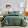A teal quilted bedding set featuring a diamond pattern is displayed on a bed against a white wall.