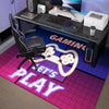 A purple and pink hexagonal gaming area rug with neon lettering that is placed under a dark desk setup.