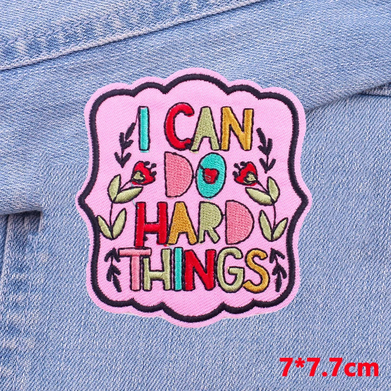 Pink embroidered patch with text I CAN DO HARD THINGS on a denim fabric background