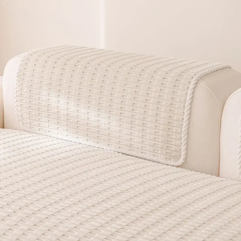 A cream-colored sofa cover with a textured, quilted white fabric draped over the back.