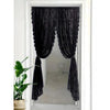 Black sheer curtain with floral embroidery hanging in a white door frame.