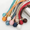 A collection of colorful, textured cord tiebacks in various shades of orange, green, brown, and gray.