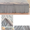 A gray plush bed skirt linen set featuring a textured fabric and matching pillows on a bed.