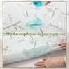A hand pours blue liquid onto a white bamboo fiber fitted sheet mattress protector, demonstrating its protective qualities.