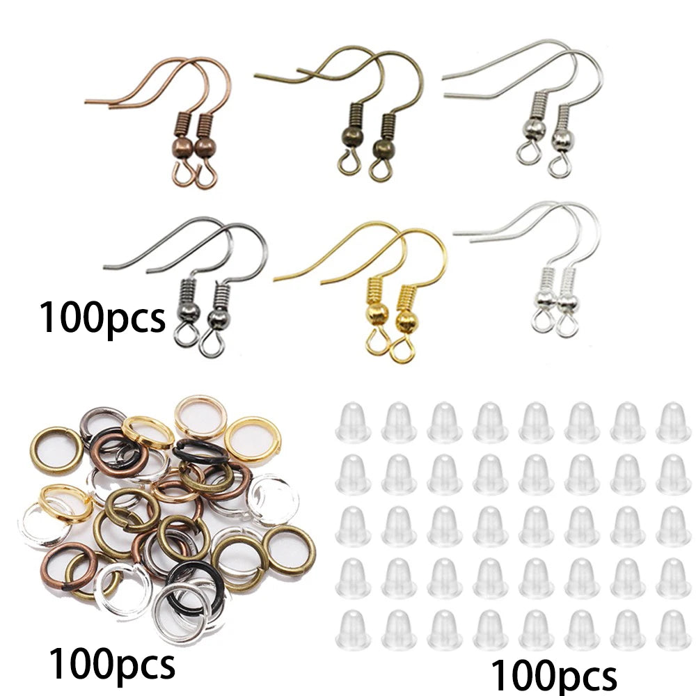 A collection of various jewelry findings including earring hooks and round metal rings in different finishes.