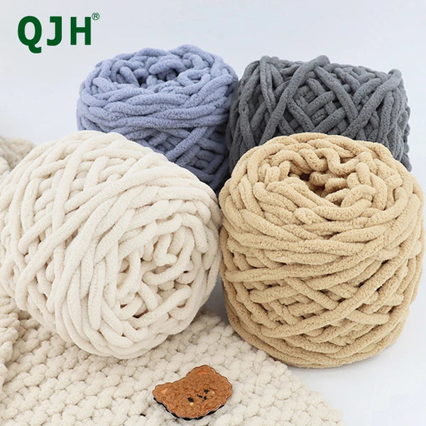 Three balls of chunky velvet knitting yarn in light blue, gray, and beige resting on a cream knitted fabric.