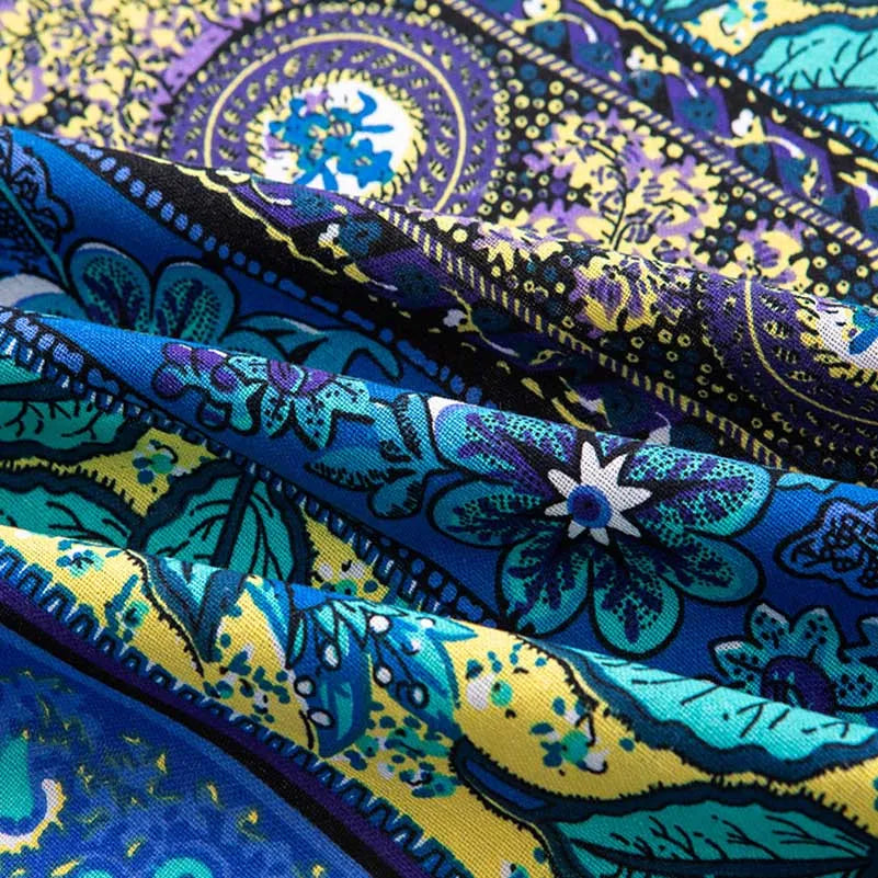Close-up of vibrant blue and yellow bohemian printed linen fabric showing intricate floral patterns.