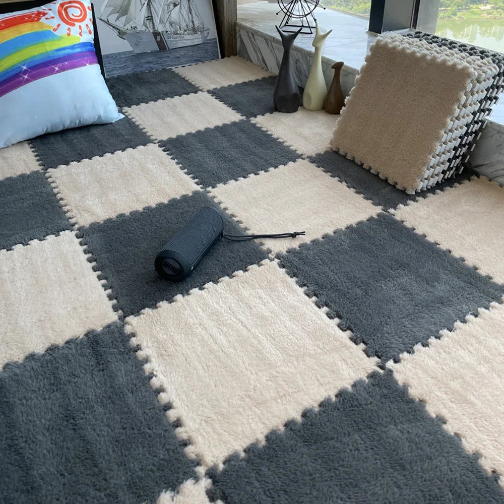 A close-up view of a gray and beige checkered play mat with a black foam roller on it, set in a bright indoor area.