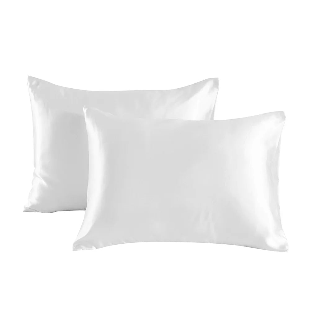 A pair of smooth white satin pillowcases lying flat.