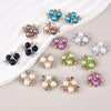 A collection of flower-shaped resin button rhinestones in various shades of blue, purple, and silver on a white background.