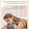 A woman is lying down comfortably on a pillow designed to support the chest curve.