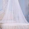 White sheer mosquito net draped over a bed, resembling a princess dome.