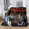 A black and white print featuring a thriller theme with faces and text on a blanket.
