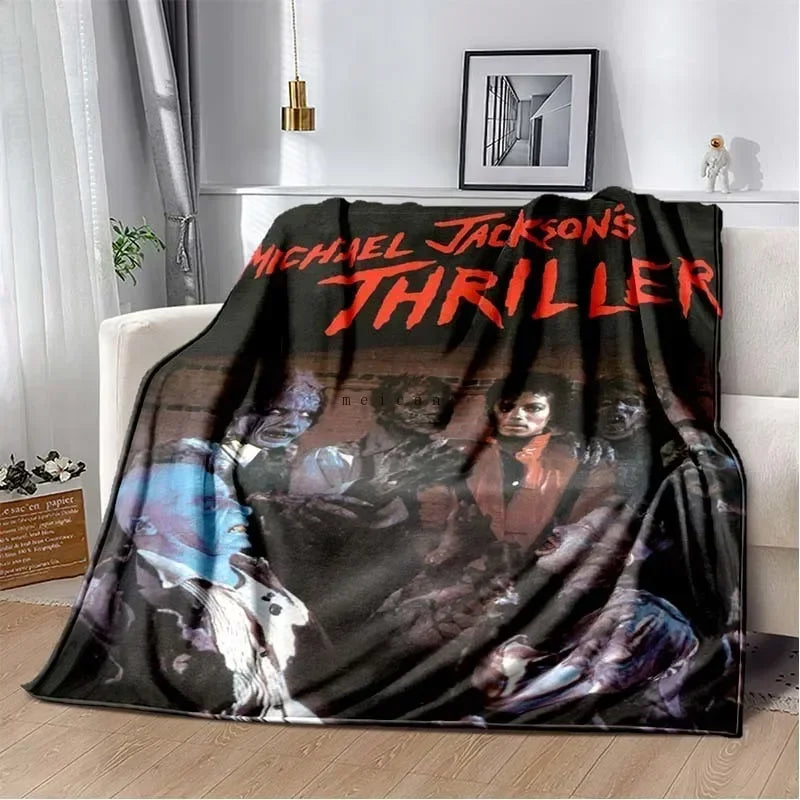 A black and white print featuring a thriller theme with faces and text on a blanket.
