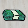 A rectangular rug featuring a green and white design resembling folded dollar bills on a light wood floor.