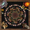 A dark mat featuring a circular design of crescent moons and floral elements for tarot readings.
